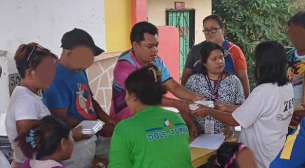 FOOD PACKS Evacuees housed at San Isidro Elementary School in Toboso, Negros Occidental, get food packs before they return to their homes over the weekend after fighting between government troops and communist rebels ended. —PHOTO COURTESY OF COUNCILOR RICHARD JAOJOCO